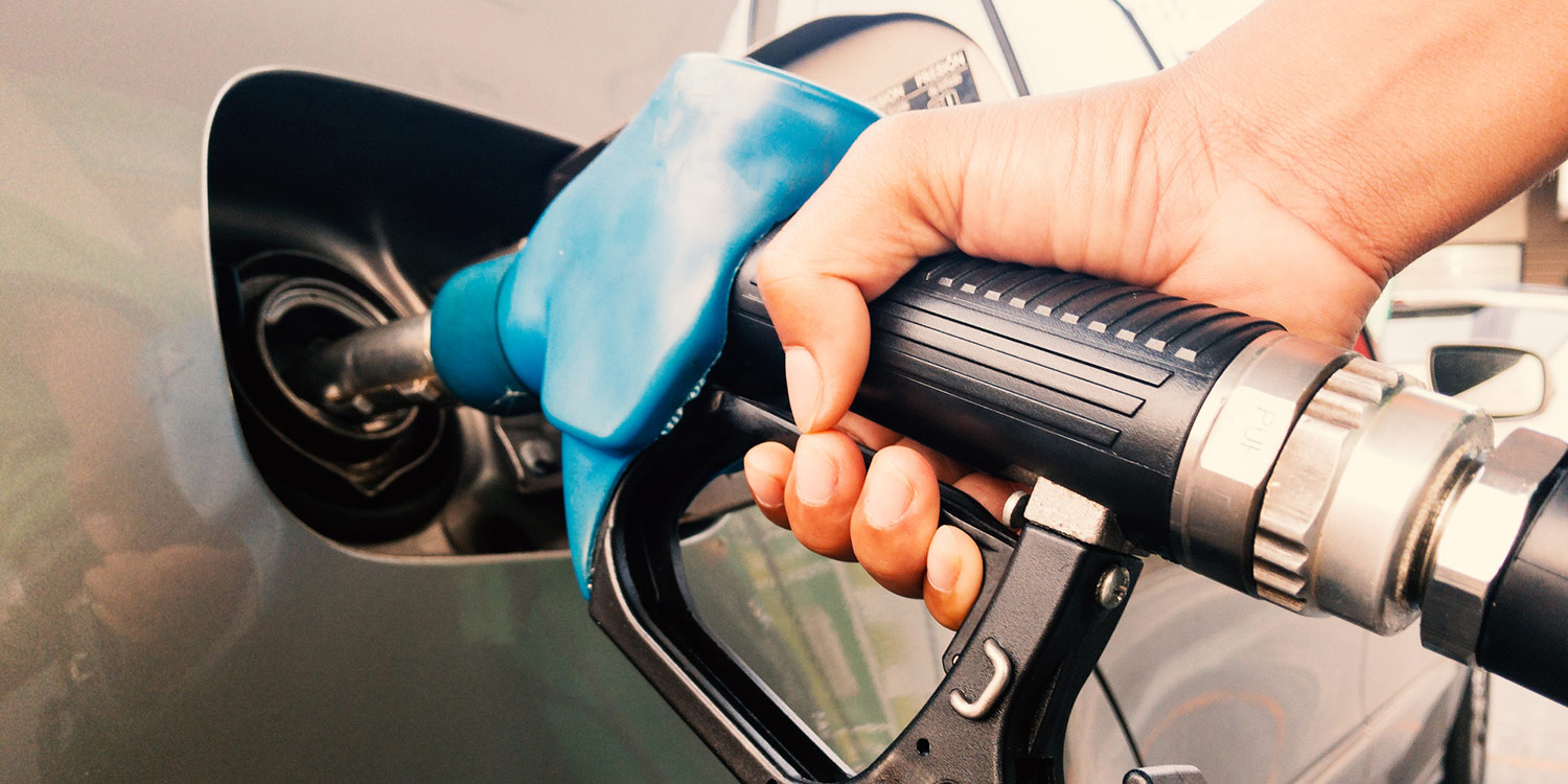 Photo of a person pumping gas into a car