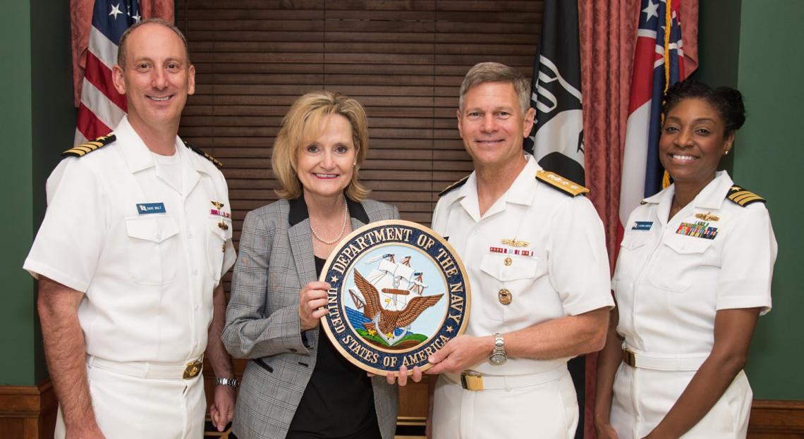 Senator Hyde-Smith accepts a U.S. Navy seal from Rear Admiral James Loeblein